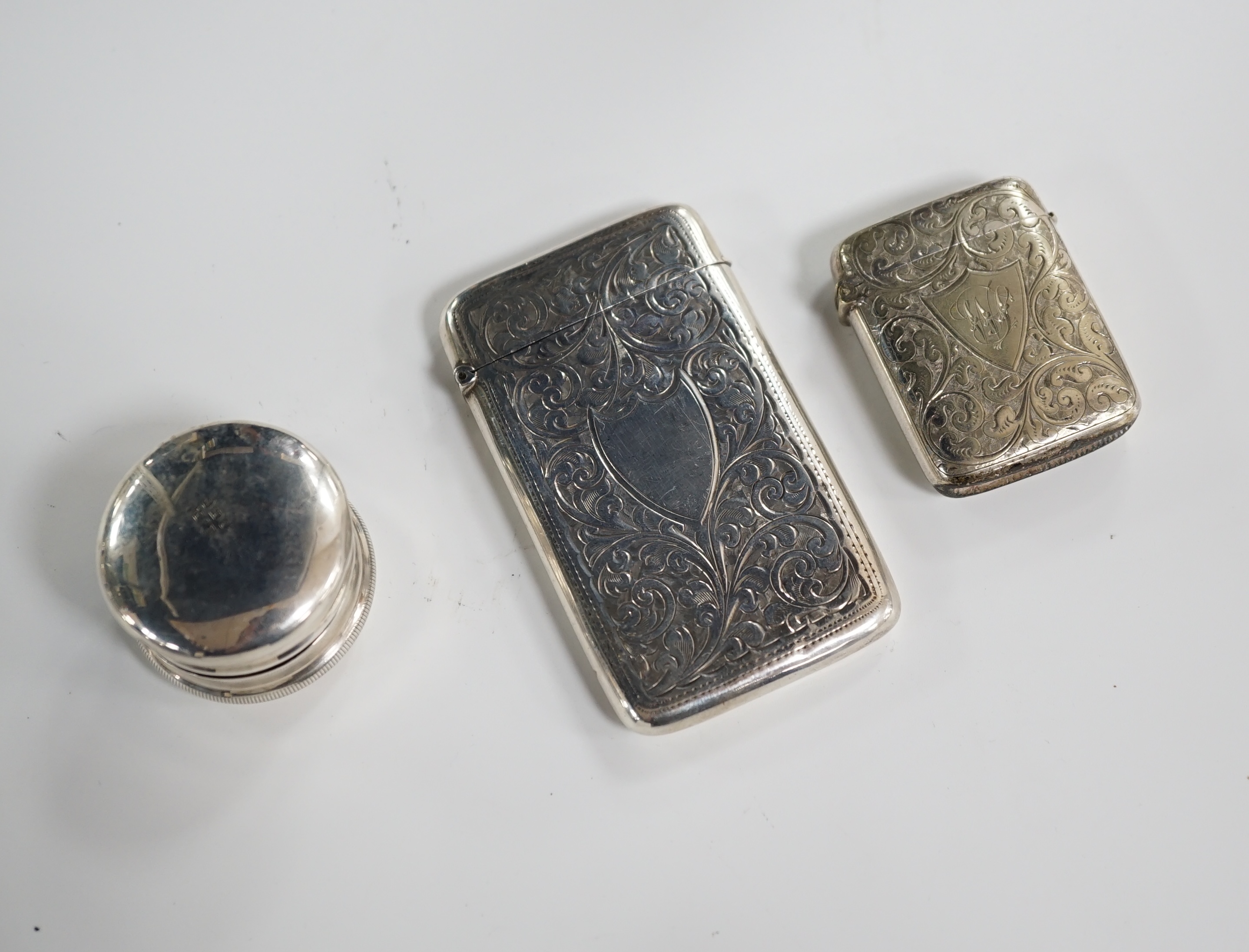 An Edwardian engraved silver card case, Birmingham, 1906, 84mm, together with a silver plated vesta case and a silver pill box. Condition - card and vesta cases, fair, pill box mis-shapen